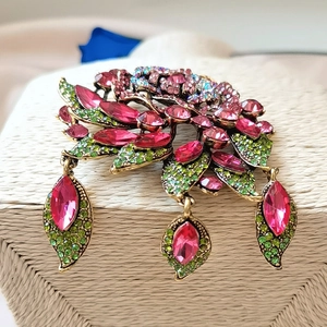 Macro shot of large baroque flower brooch with pink crystals and teardrop pendants