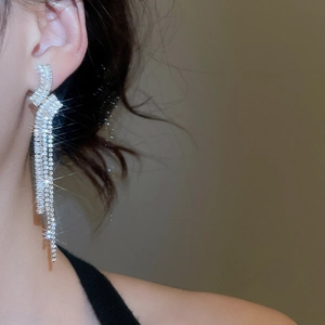 Dettaglio di orecchini a nappa in argento con zirconi a cascata indossati da una modella elegante