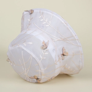 Détail du chapeau de soleil en dentelle blanche avec broderie papillon et tissu mesh
