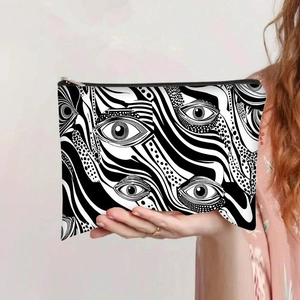 Detalle del neceser de lona con estampado de ojo surrealista y cierre de metal