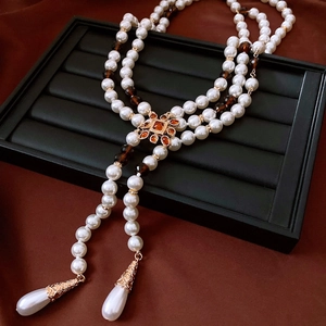Detail of vintage flower pendant necklace with amber crystals and teardrop pearls
