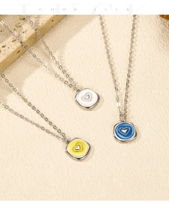 Détail des pendentifs cœur en émail et argent S925 en blanc, jaune et bleu ciel