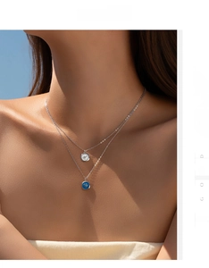 Gros plan du collier double couche en argent S925 avec pendentifs cœur en émail blanc et bleu
