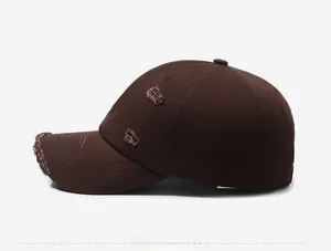 Close-up of distressed ripped details on a vintage washed coffee brown baseball cap