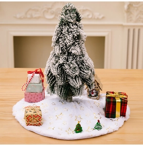 Detail of white plush Christmas tree skirt featuring golden foil star patterns and soft texture