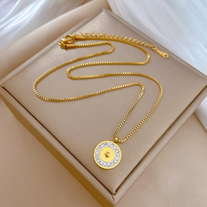 Detailed macro view of a gold-plated titanium steel box chain with a round zircon pendant