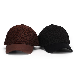 Detailed view of floral texture on black and brown baseball caps with decorative stitching