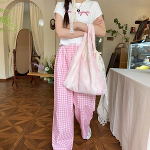 Detail of pink gingham wide-leg pants with elastic drawstring waist and embroidery
