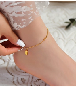 Close-up of gold titanium steel anklet with engraved square pendant and dainty chain