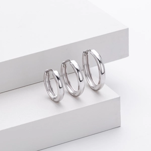 Three pairs of polished S925 sterling silver hoop earrings in varying sizes on white steps