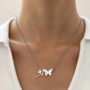 Dettaglio della collana in acciaio argento con ciondolo lettera A, cuore e farfalla