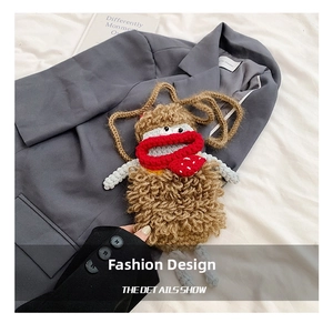 Detail showing handcrafted brown crochet monster bag with red lips and strawberry charm