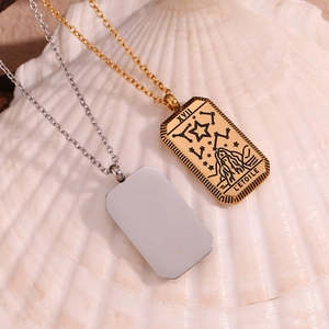 Detail of 18K gold and silver Tarot Strength card pendants on shell background