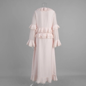 Detail view of the layered ruffles and soft texture on the back of a light pink maxi dress