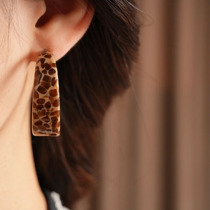 Close-up of tortoise shell acetate C-shaped hoop earrings with retro leopard pattern