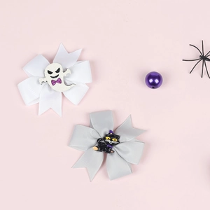Detail of handmade Halloween hair clips featuring a white ghost and a black cat witch