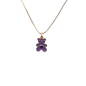 Joli collier doré avec pendentif ours violet et détail cœur sur fond blanc épuré
