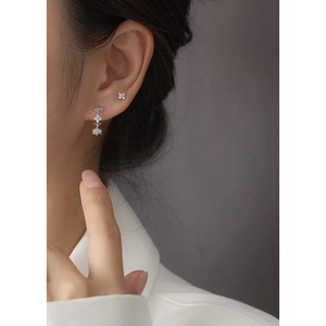 Macro shot of S925 silver four-leaf clover earrings with sparkling cubic zirconia stones