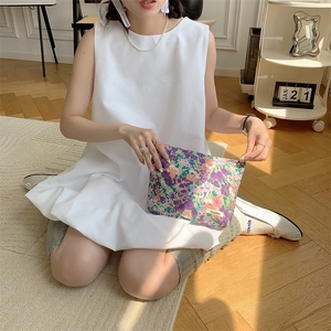 Floral cotton makeup pouch with Sozakka label held by a person in a cozy setting