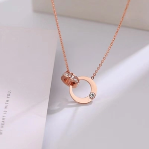 Macro shot of 18k rose gold double ring pendant with pavé zircons and a single diamond