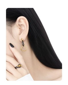 Close-up of dual-tone black and gold rings with textured irregular geometric surface