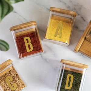 Top-down view of airtight borosilicate glass jars with bamboo lids on marble background