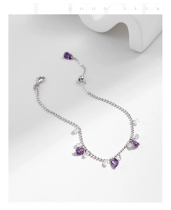 Dettaglio del bracciale a sfere argentate con cristalli a goccia viola e chiusura regolabile