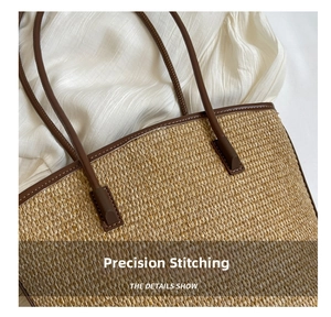 Detailed view of the fine stitching on the brown leather strap of the straw tote bag