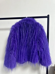Detail of dark purple faux fur coat with long fibers on a black metal hanger