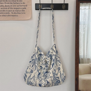 Close-up of vintage blue floral print canvas tote bag hanging in a cozy home setting
