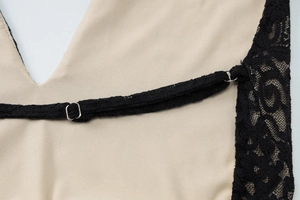 Detail of apricot fabric with black lace trim and adjustable metal strap buckle