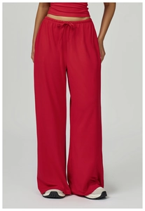 Close-up of red wide-leg sports pants with drawstring waist and soft draped fabric