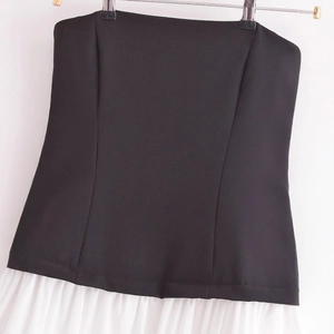 Elegant strapless midi dress in black and white patchwork with a pleated hem skirt
