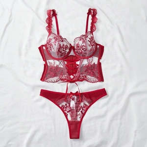 Flat lay of red lace lingerie set with corset-style underwire bra and floral thong
