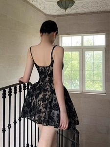 Détail d'une robe en dentelle noire élégante avec jupe évasée et design sans manches