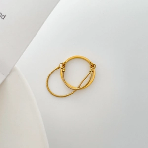 Detail of a gold-plated double-layer ring featuring a polished band and sleek snake chain