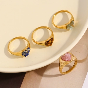 Detail von vier herzförmigen 18K vergoldeten Ringen mit bunten Naturstein-Inlays