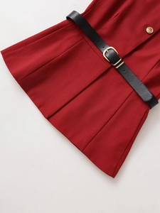 Close-up of red vest top featuring a black leather belt with golden metal buckle