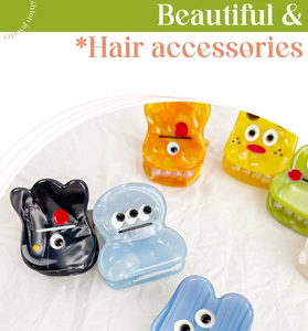 Detail shot of colorful mini cartoon monster hair clips in acetate with vivid facial details