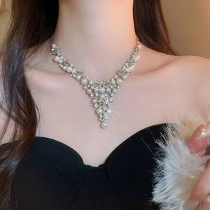 Détail d'un collier de luxe en V avec perles blanches et strass étincelants sur un mannequin