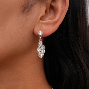 Gros plan de boucles d'oreilles géométriques argentées scintillantes sur un mannequin