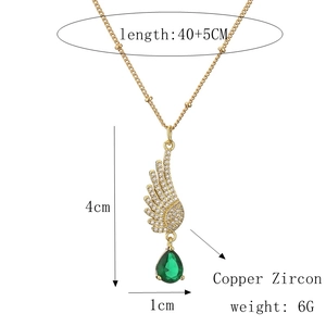 Detail view of gold angel wing necklace with size specifications and green gem