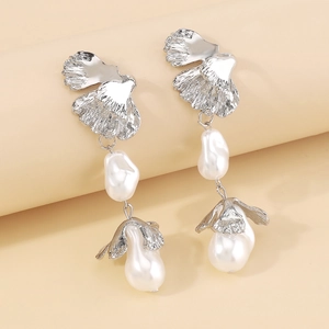 Detailed macro view of baroque pearl earrings with textured silver leaf petal design