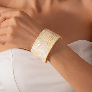 Detail of wide acrylic open bangle featuring marble texture on model's wrist