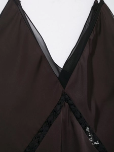 Dettaglio dello scollo a V con pizzo nero e mesh sul vestito di raso marrone