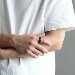 Men's 8mm brushed matte black stainless steel wedding ring worn by a model