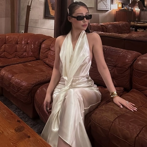 Vue détaillée d'une robe dos nu en satin blanc montrant le tissu brillant et les lacets