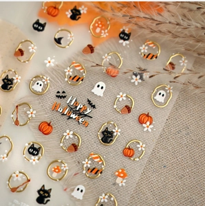 Detail of 3D Halloween nail stickers featuring pumpkins, black cats and golden accents