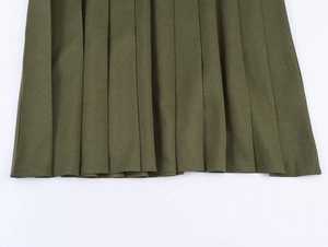 Vue détaillée de la texture plissée et du tissu de cette élégante jupe verte style anglais