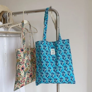 Detailed macro view of two vintage floral canvas tote bags with Indian block print patterns